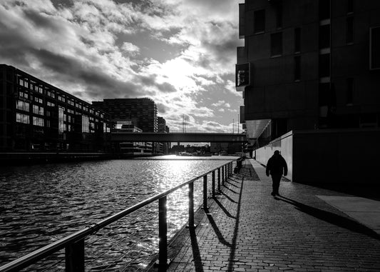 Mann spaziert am Kölner Hafen mit Severinsbrücke Sonne und Wolken